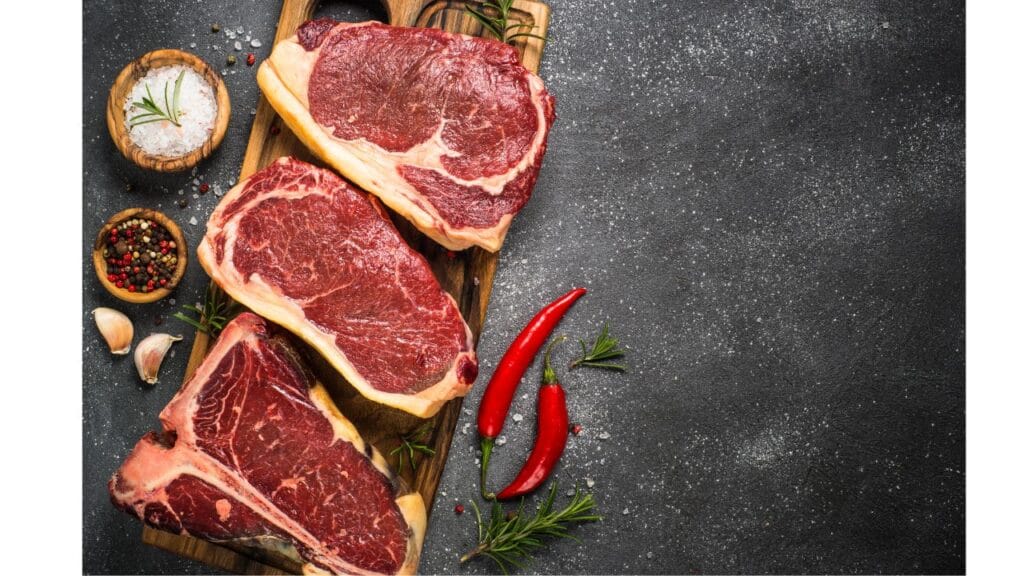 Various cuts of steak including sirloin, fillet, rump, and rib eye displayed on a wooden cutting board.